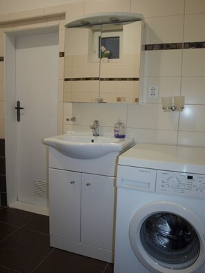 A compact laundry area with a washing machine and a sink. - Apartment in favorite area Decin-Letna (Decín)