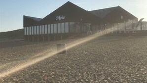 Un bâtiment dont la façade porte l’inscription « Moio Beach ».
