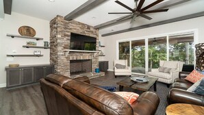 A spacious living room with a stone fireplace, leather sofas, and a large window offering a view of the outdoors. - Stay awhile and RELAX at Lake Keowee, Clemson and the mountains!
The 5 Seasons (West Union)