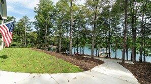 Enjoy a serene outdoor setting with a well-maintained lawn, pathway, and tranquil water feature surrounded by tall trees.