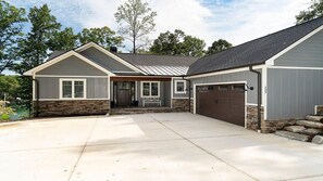 Enter through the front door to a two-story house with a covered porch and garage.