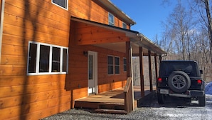 A wooden house with a covered porch and a parked SUV. - Gorgeous Mountain View 8 miles from Appalachian Trail (Roan Mountain)
