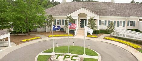 A building with a central lawn area marked with 'TPC' and multiple flags, including the American flag.