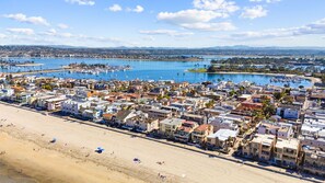 A coastal town with a beach, marina, and residential buildings.