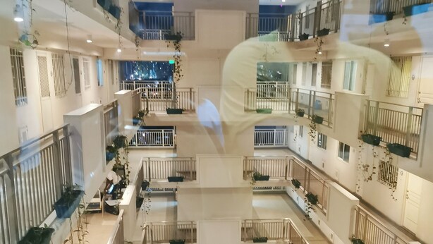 Un atrium à plusieurs niveaux, doté de balcons, de rampes et de plantes en pot.