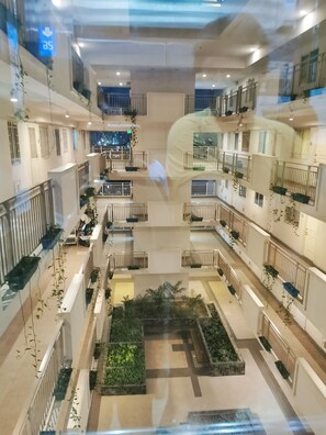 A multi-level atrium with balconies, railings, and potted plants. - 2 Beds Penthouse End Unit, Great Panoramic City View w/FREE Parking  (Sampaloc)