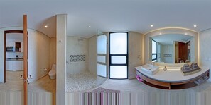 A modern bathroom with a large mirror, a shower, and a vanity with a sink.