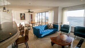 Una sala moderna con un sofá azul, una mesa de centro de madera y un comedor con una mesa y sillas.