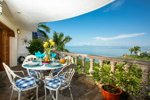 A terrace with a round table, chairs, and a potted plant. - Beautiful & relaxing Condo Azul in prestigious Conchas Chinas (Puerto Vallarta)