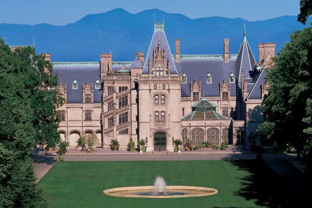 A large, historic building with a central courtyard and a fountain.