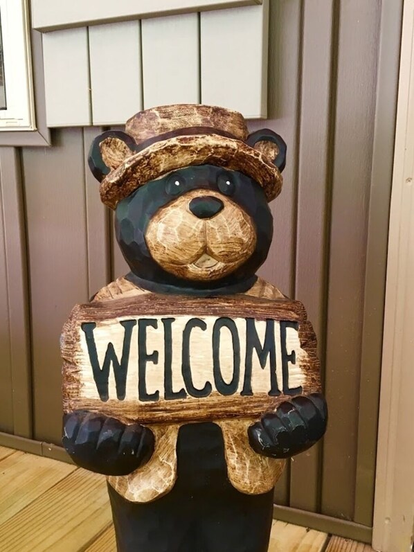 Un letrero de madera con forma de oso que dice 'WELCOME'.