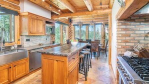 Une cuisine spacieuse avec des meubles en bois, un grand îlot central et une cuisinière à gaz.