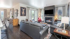 A modern living room with a fireplace, leather sofas, and a flat-screen TV. - Cassidy Ridge C301- Fawns Leap (Telluride)