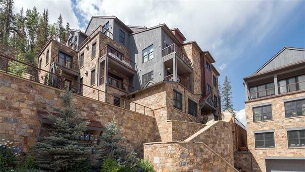 A multi-story building with stone exterior walls and balconies. - Cassidy Ridge C301- Fawns Leap (Telluride)