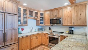 A kitchen with wooden cabinets, a microwave, a toaster, and an oven. - Riverside B02 (Telluride)