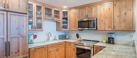 A kitchen with wooden cabinets, a microwave, a toaster, and an oven.