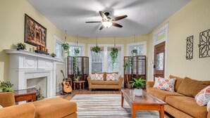 A living room with a fireplace, a ceiling fan, and a sofa. - Austin Oasis Near UT and Downtown (Austin)
