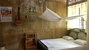 Una habitación con cama, una guitarra, un calendario y un mosquitero.