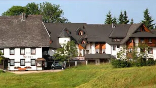 Ein großes, mehrgeschossiges Gebäude mit einem markanten Mittelbau und kleineren Flügeln.