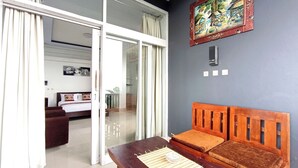 A modern room with a wooden bench, a glass door leading to a balcony, and a painting on the wall. - La Montana (Gobleg)