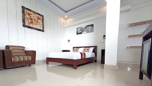 A bedroom with a bed, a chair, and artwork on the walls. - La Montana (Gobleg)