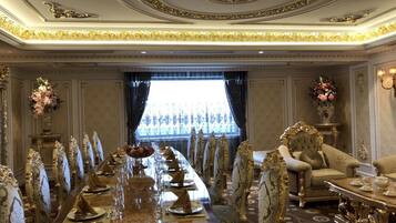 Un comedor formal con una mesa larga, sillas ornamentadas y un sofá lujoso.