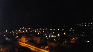 Paisagem urbana noturna com luminárias e edifícios.