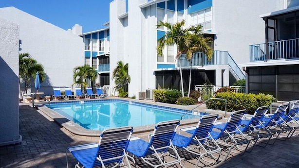 A pool area with lounge chairs and a clear blue sky. - Pearl of The Sea, 1 BDRM Condo, 2nd floor, heated pool, 2 min walk to the beach  (Madeira Beach)
