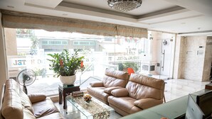 A modern living room with leather sofas, a glass coffee table, and a potted plant. - Tu Phuong Hotel (Ho Chi Minh City)