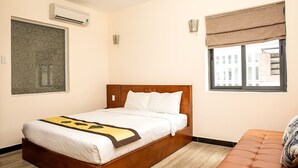 A hotel room with a bed, an air conditioner, a window with a view, and a wall-mounted artwork. - Tu Phuong Hotel (Ho Chi Minh City)