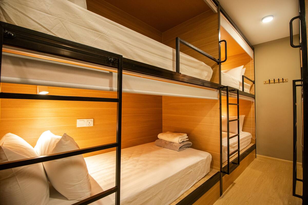 A bunk bed room with wooden walls and a ceiling light.