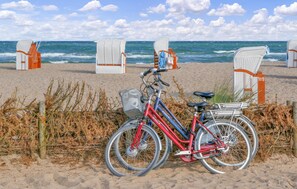 A beach with beach chairs and a bicycle.