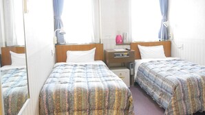 A hotel room with two single beds, a bedside table with a lamp, a heater, and a small cabinet. - Station Business Hotel Tenshukaku Hitoyoshi (Hitoyoshi)