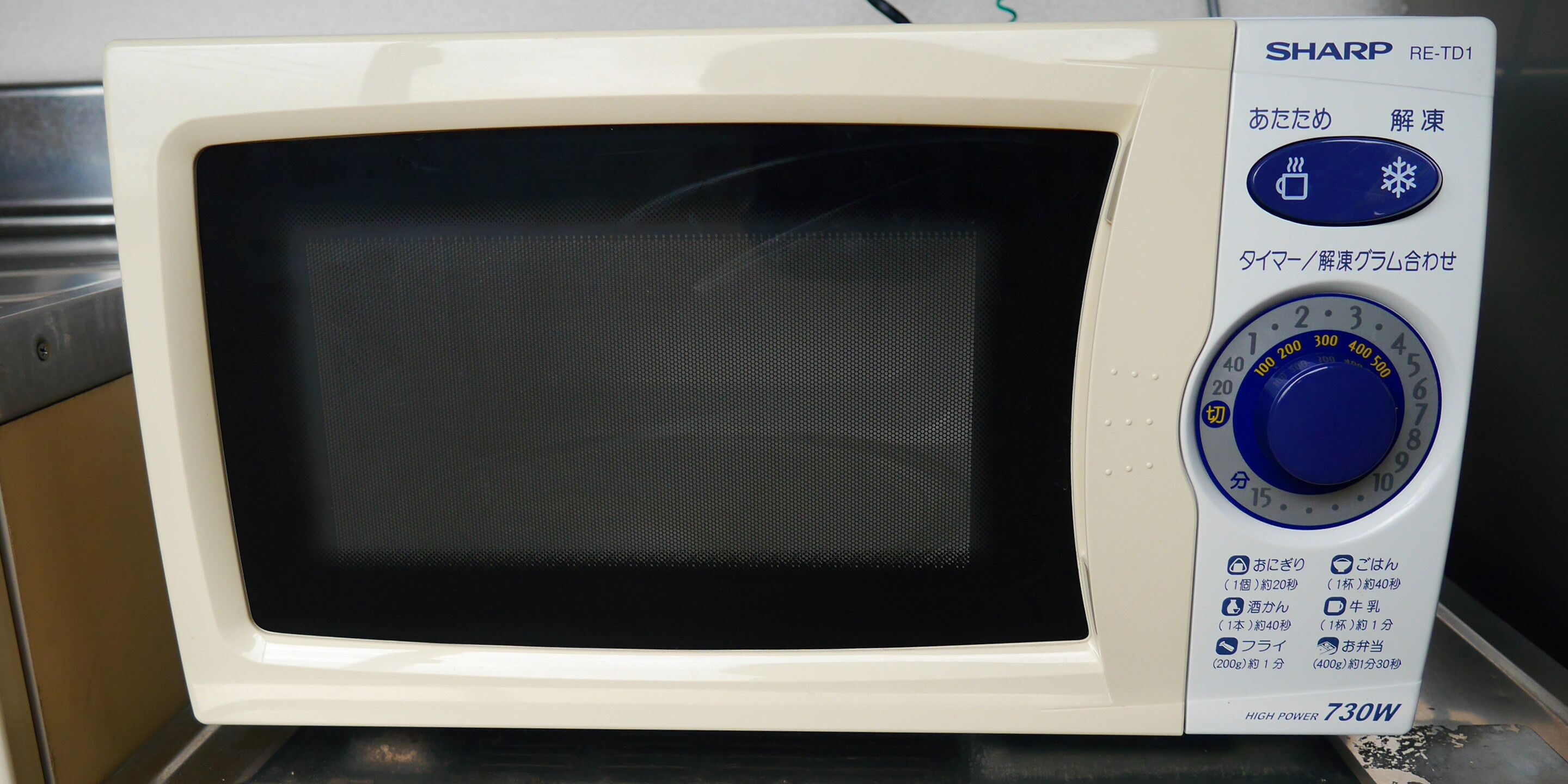 Un four à micro-ondes Sharp doté d’un écran numérique et d’un bouton de mise en marche.