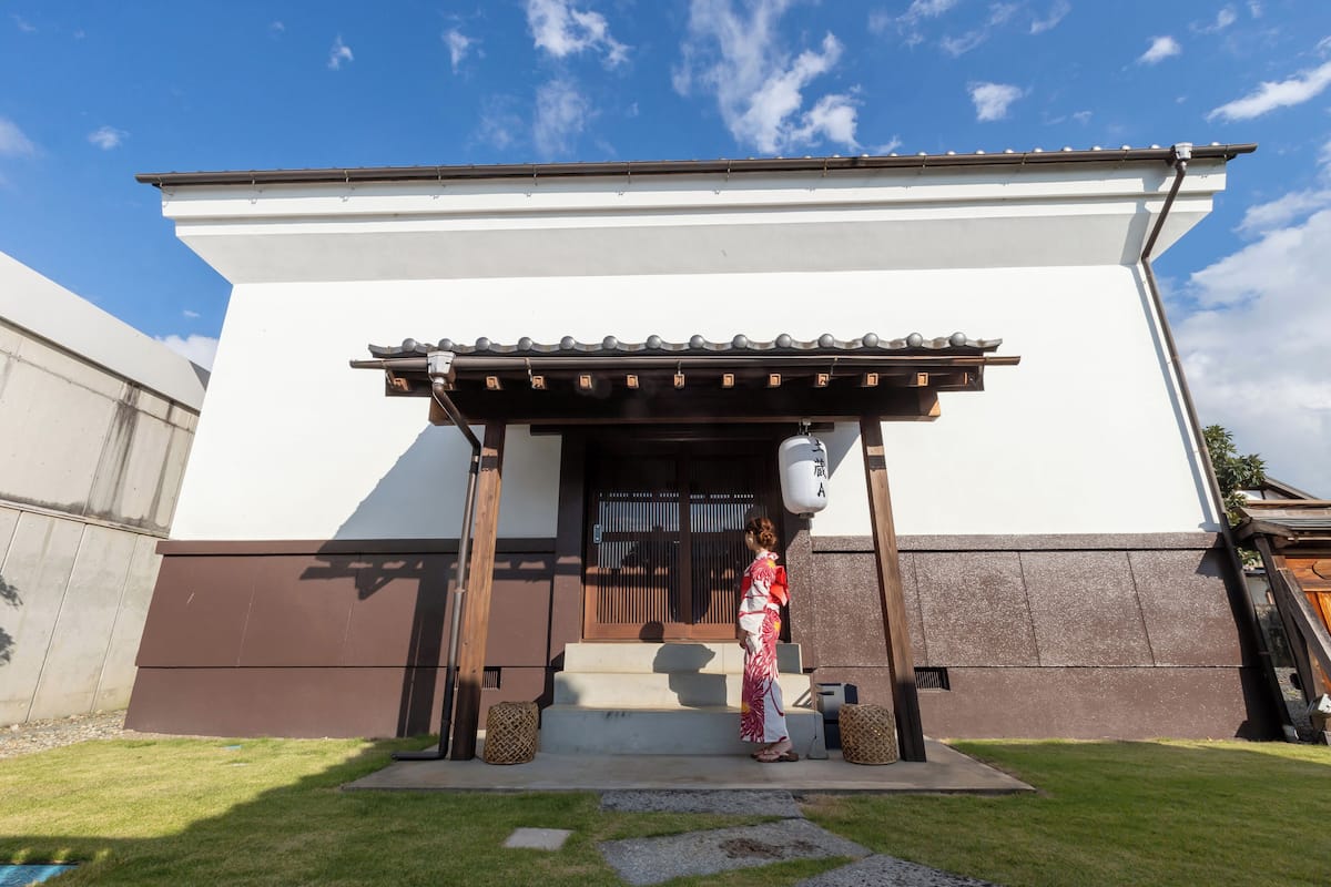 A traditional Japanese building with a white exterior and a wooden entrance.