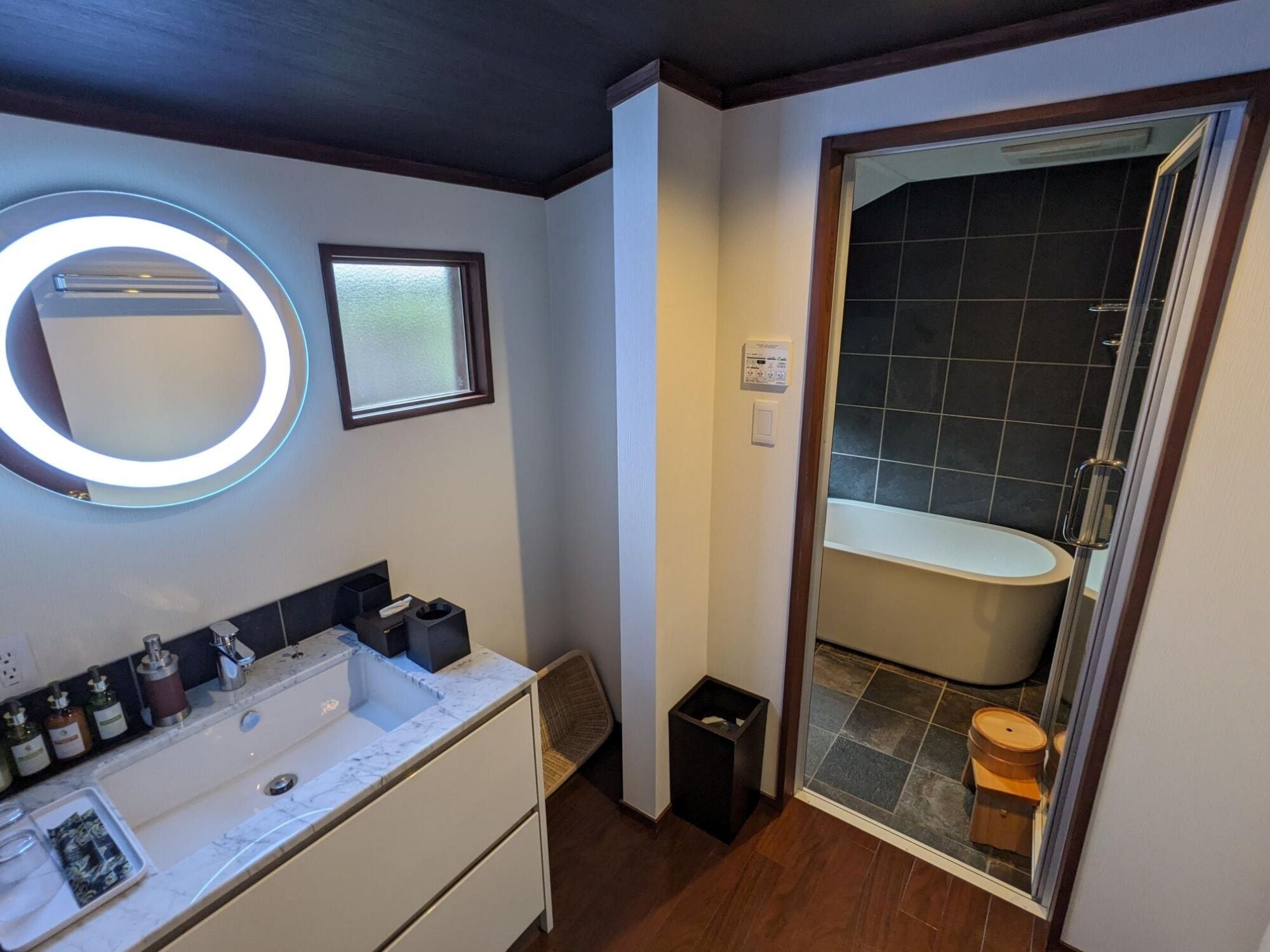 A modern bathroom with a large sink, mirror, and toilet.