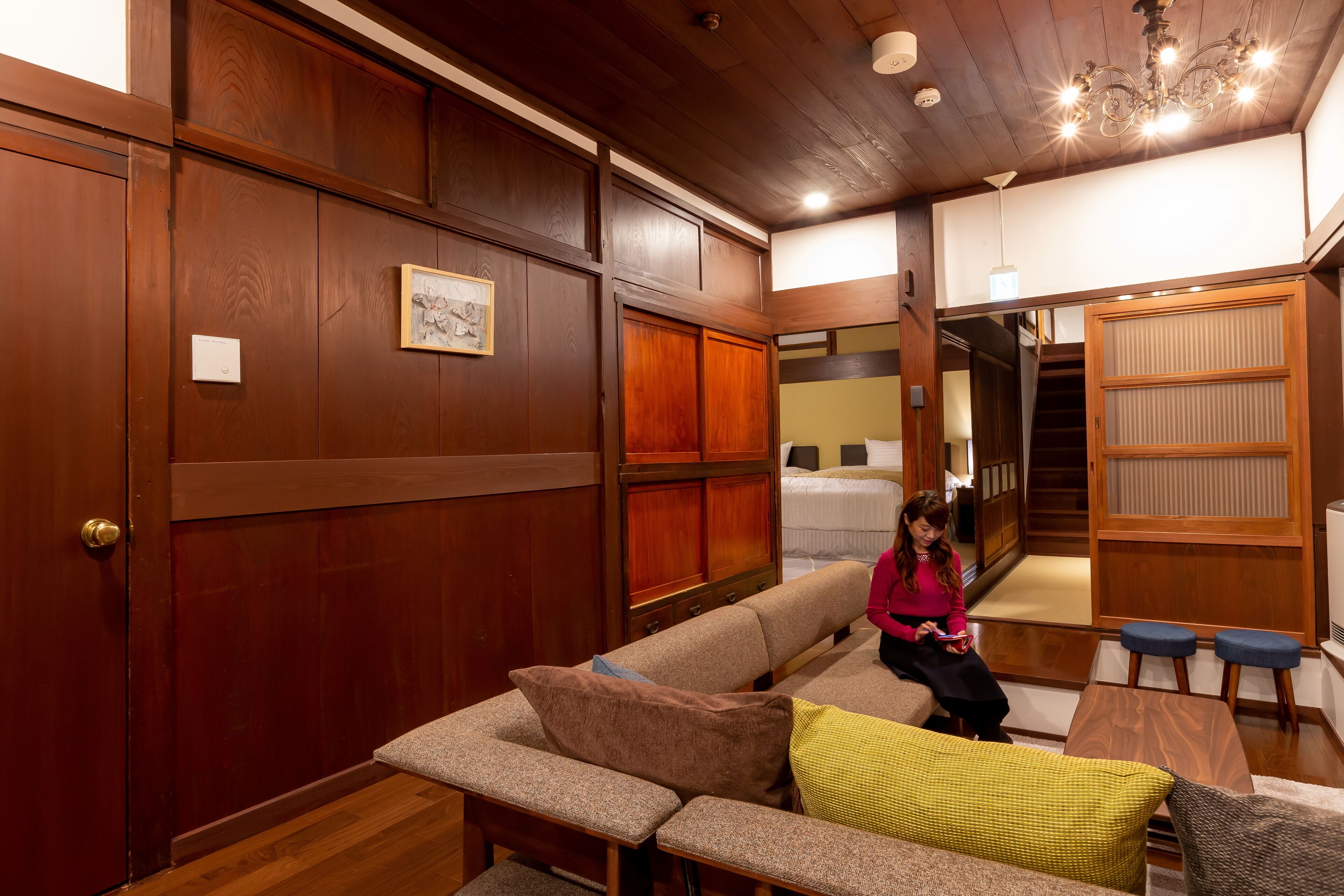 A cozy room with a wooden ceiling, a sofa, a small table, and a bench.