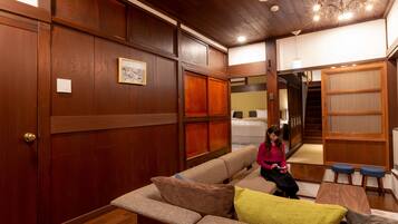 A cozy room with a wooden ceiling, a sofa, a small table, and a bench.