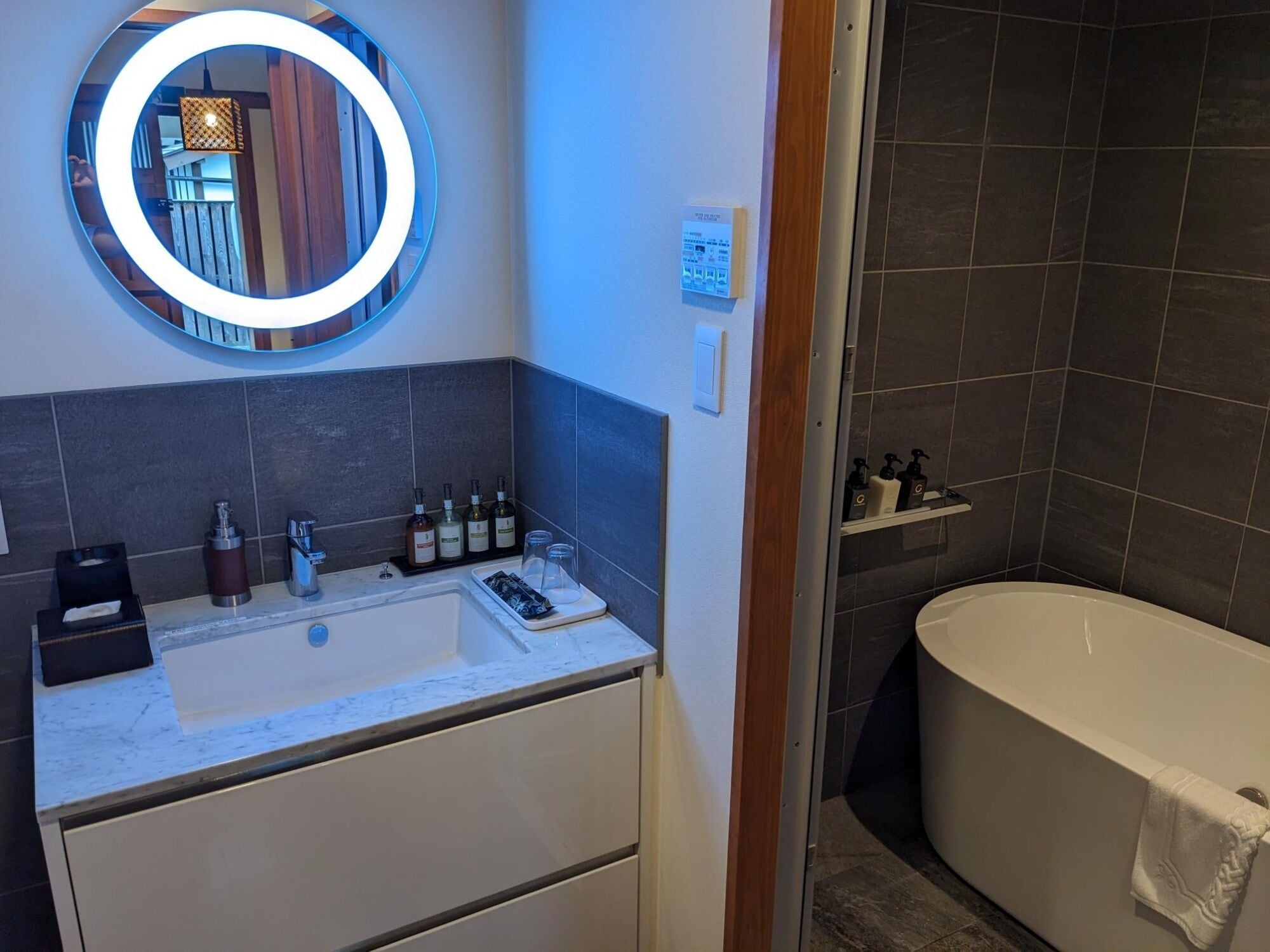 Un baño con un espejo grande, un lavabo y una bañera.