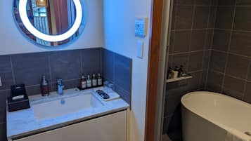 Un baño con un espejo grande, un lavabo y una bañera.