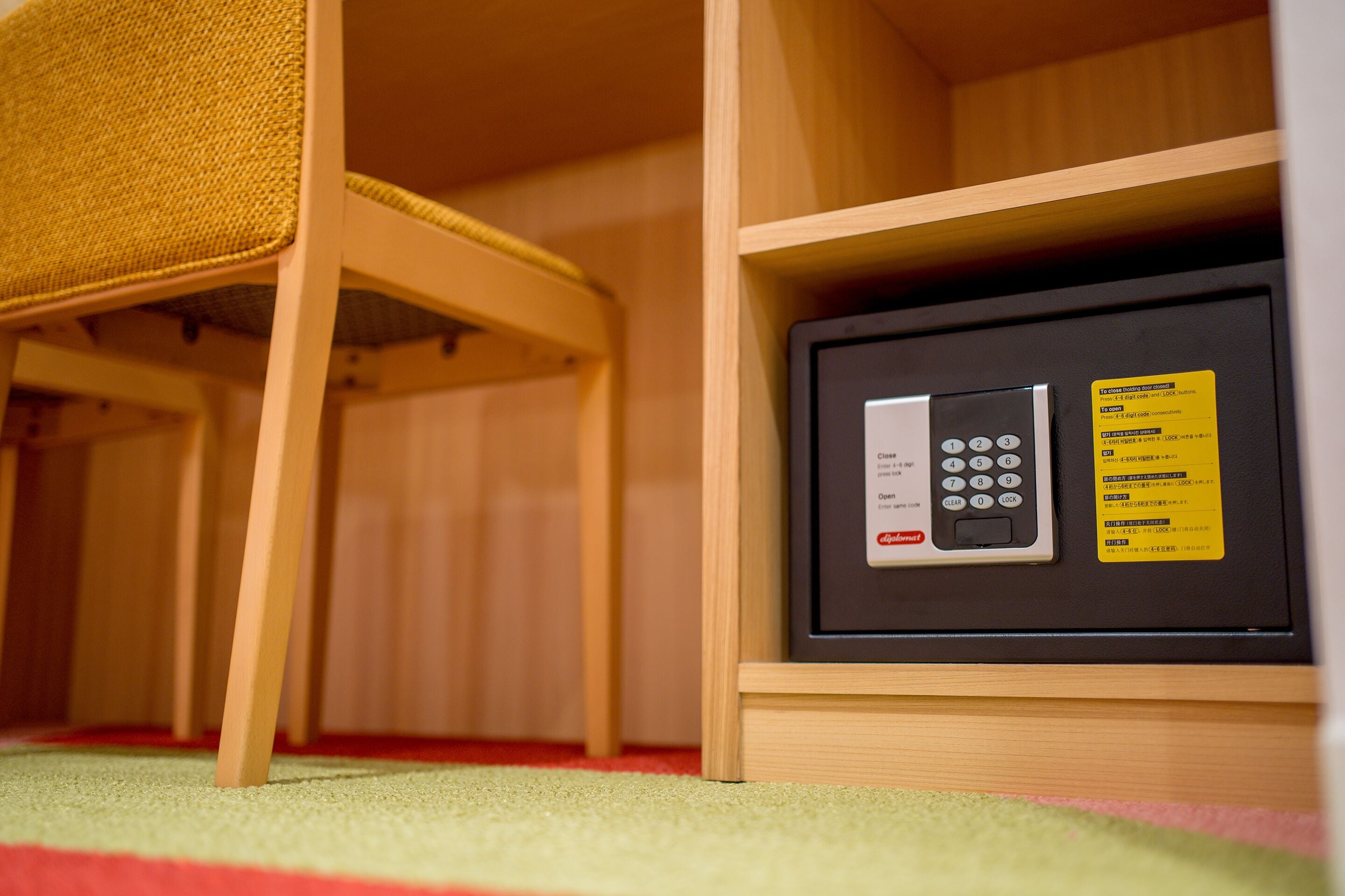 A safe with a keypad and instructions, placed in a wooden cabinet.