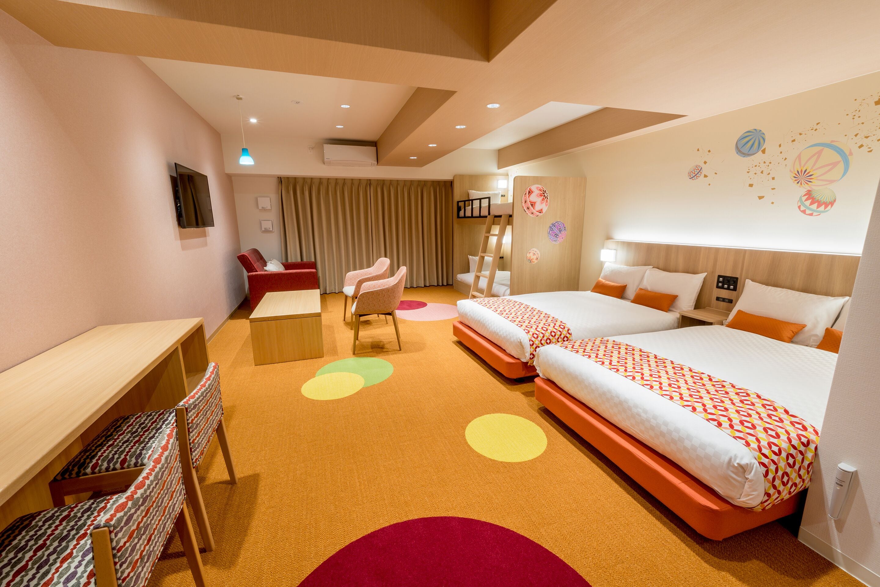 A hotel room with two beds, a desk, and a chair.