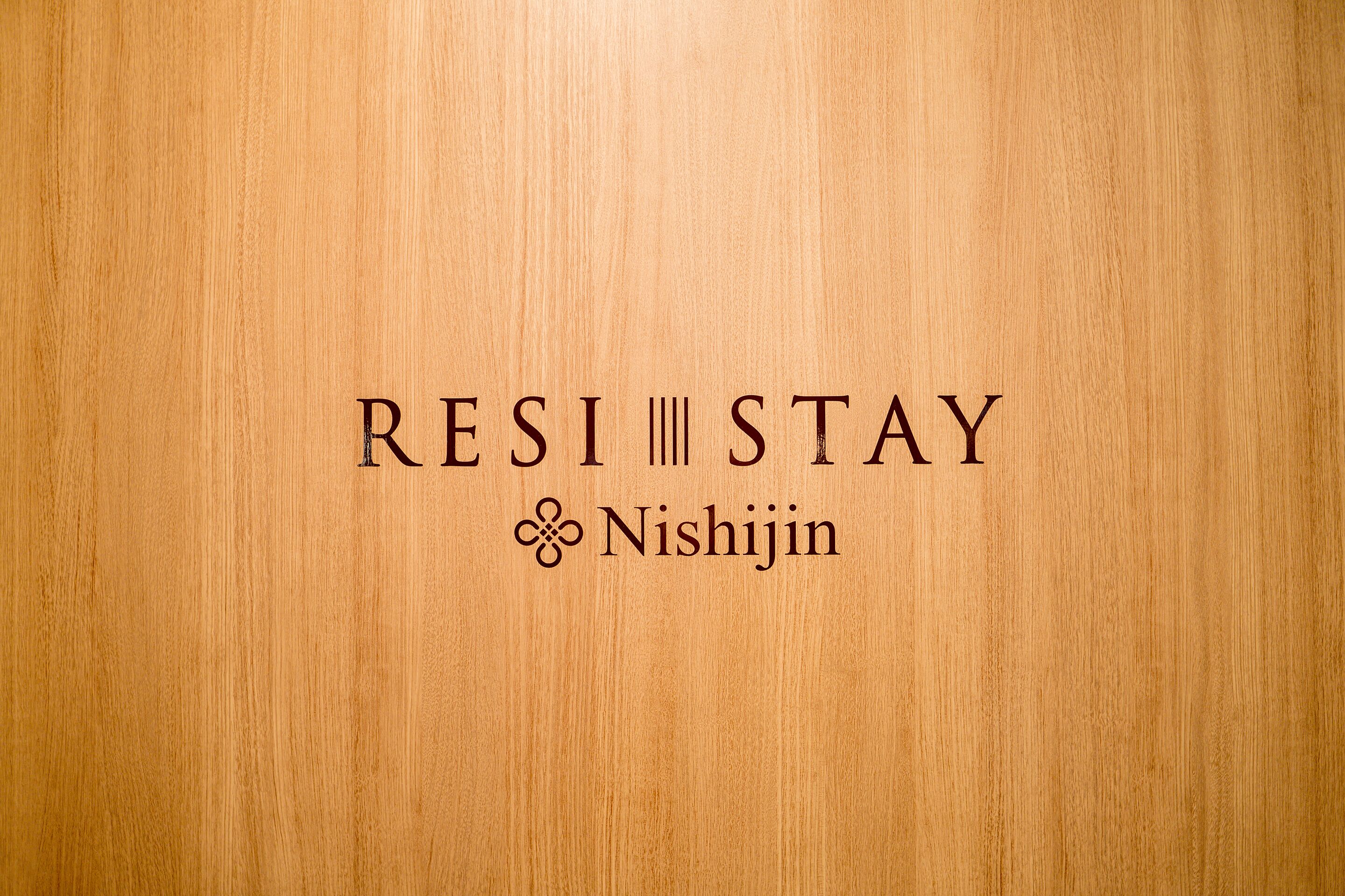 Un arrière-plan texturé en bois avec le texte « RESI STAY » et le logo « Nishijin ».