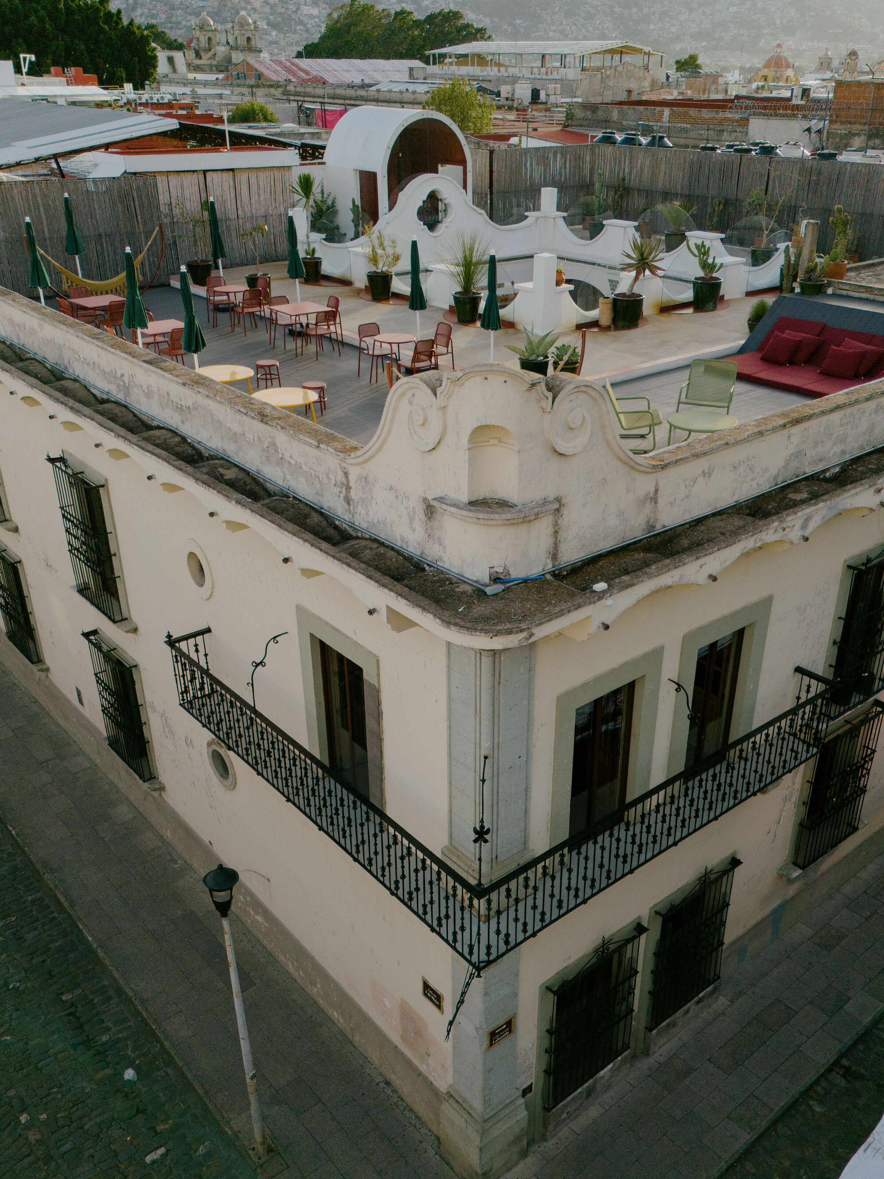 A building with a rooftop patio featuring outdoor seating and potted plants.