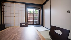 A traditional Japanese room with tatami flooring, a sliding door, and a view of the outside. - Kiyomizuya (Kyoto)