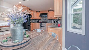 Een moderne keuken met houten kastjes, een centraal eiland en een eetgedeelte met een houten tafel.