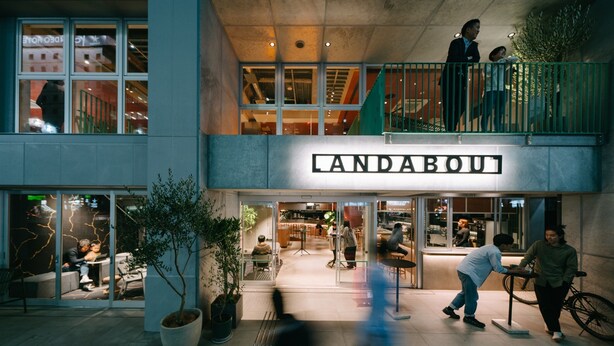 A modern building with a prominent 'LANDABOU' sign. It features a spacious outdoor seating area with tables and chairs, surrounded by potted plants. - LANDABOUT TOKYO (Tokyo)