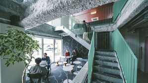 A modern interior with a staircase, seating areas, and a large potted plant. - LANDABOUT TOKYO (Tokyo)