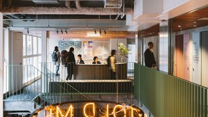 A modern reception area with a glass wall, a reception desk, and a staircase leading to an upper level. - LANDABOUT TOKYO (Tokyo)