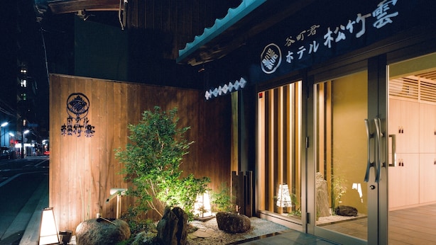 Ein Gebäude mit einer Holzfassade und einem Schild mit japanischen Schriftzeichen.